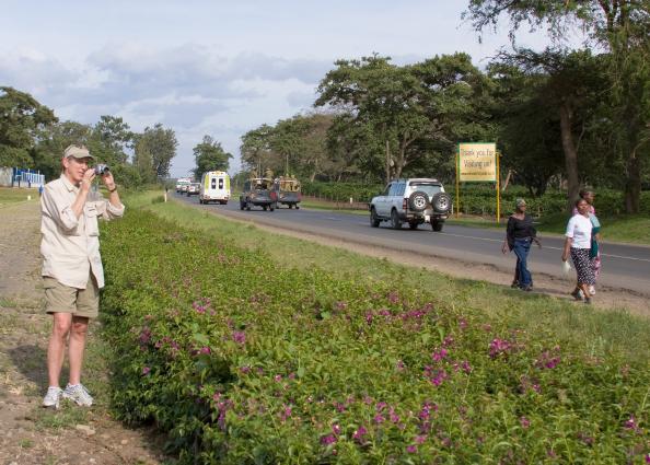 Arusha-7014.jpg - Jim filming presidential motorcade because the only road was closed until he cleared the area.